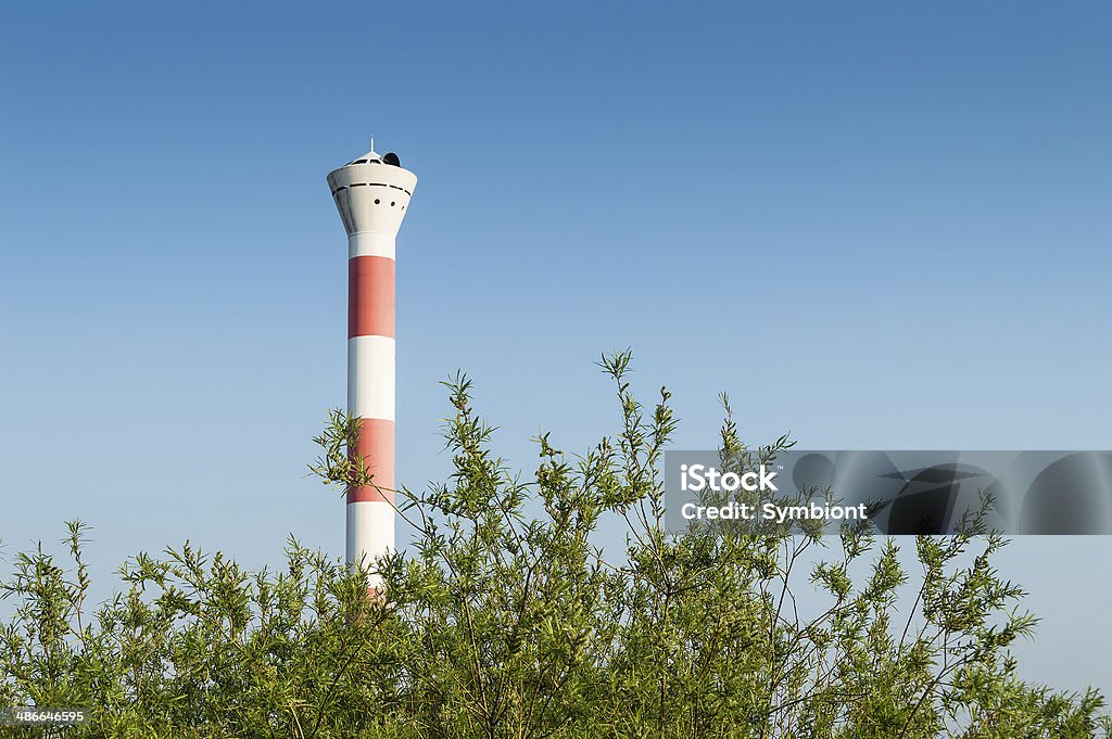 Lighthouse Hamburg The lighthouse at the beach of Blankenese in Hamburg - Germany. It´s at the entrance of the Hamburger Hafen / harbor of Hamburg. Selective focus with some plants in the foreground. Blue clear sky with copy space in the background. American Beachgrass Stock Photo