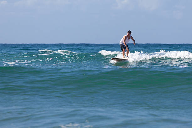 surfer reitet auf dem longboard befördert eine welle im meer - surfing surf wave extreme sports stock-fotos und bilder