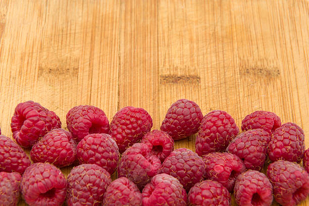 istock Ripe sweet raspberries on wood table close-up 486647554