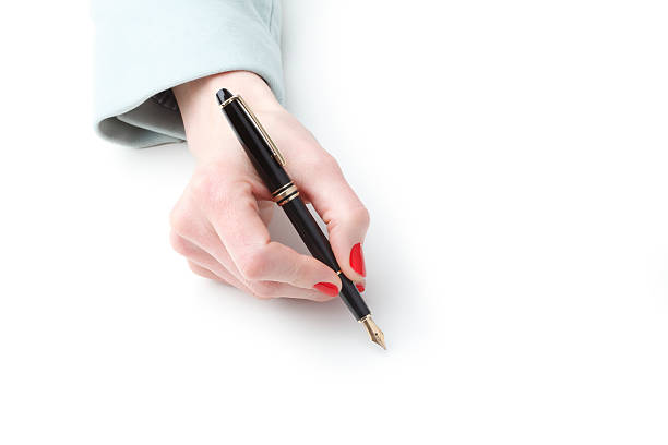 Close-up of businesswoman with fountain pen Close-up of businesswoman writing with fountain pen on white paper. red nail polish stock pictures, royalty-free photos & images