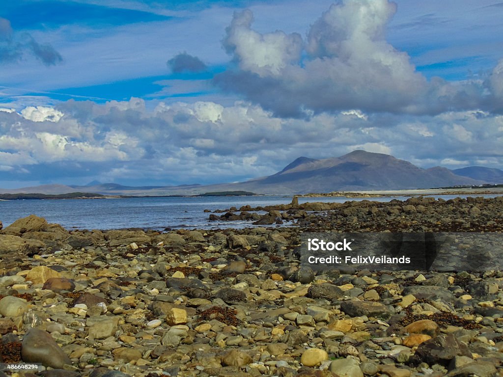 Rocky Shore Rocky shore with Atlantic Ocean and mountain in background. Blue cloudy sky. 2015 Stock Photo