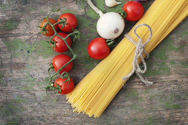 Spaghetti with vegetables on wooden background stock photo