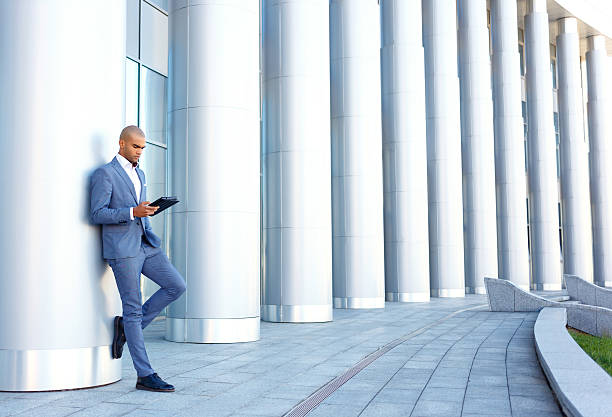 istock Upbeat businessman standing near column 486649458