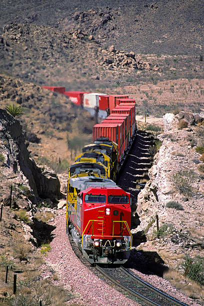 istock Red loco and container train in rugged canyon 486650191