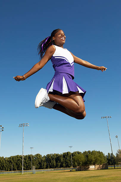 Cheerleader Mid-air Cheerleader Mid-air cheerleader photos stock pictures, royalty-free photos & images