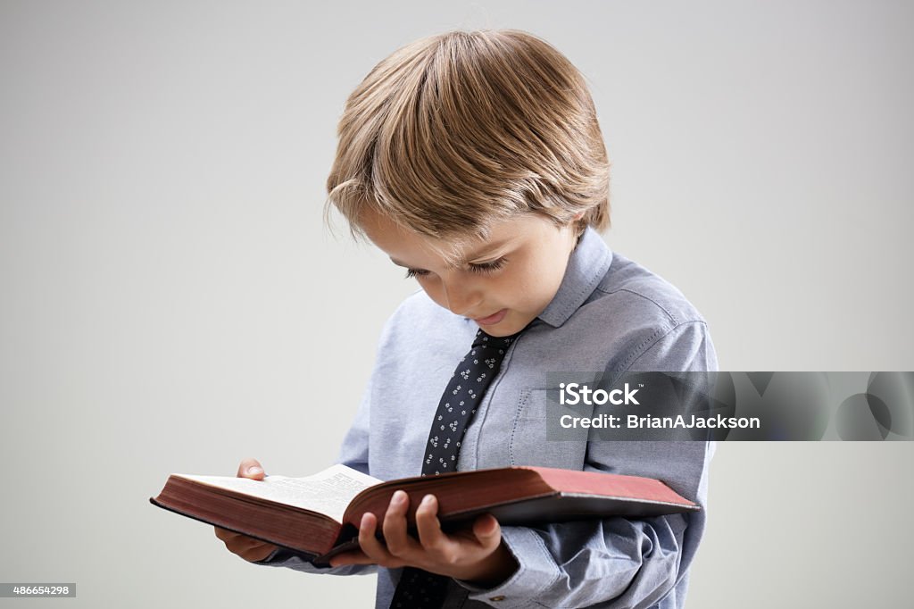 Niño Leyendo Un Libro O Biblia Foto de stock y más banco de imágenes de Niño  - Niño, Biblia, Estudiar - iStock