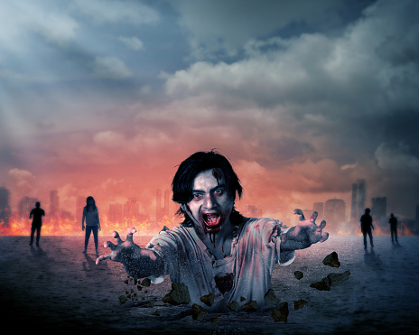 Creepy male zombie out from the ground with destroyed city background