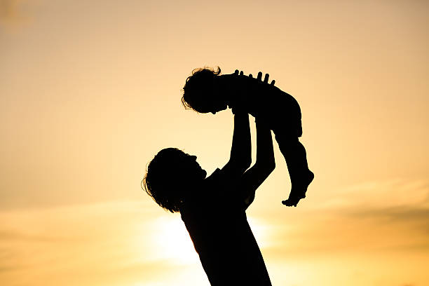 istock Father and little daughter silhouettes at sunset 486657798