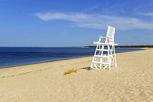 istock White lifeguard chair on empty sand beach with blue sky 486663772