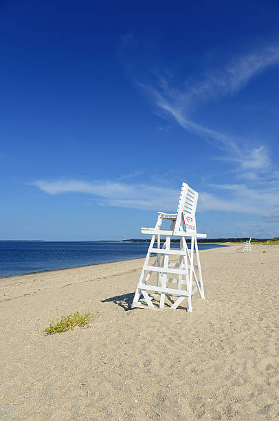 istock White lifeguard chair on empty sand beach with blue sky 486664028