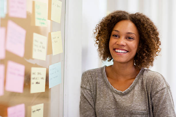 Entrepreneur smiling in front of her task cards stock photo