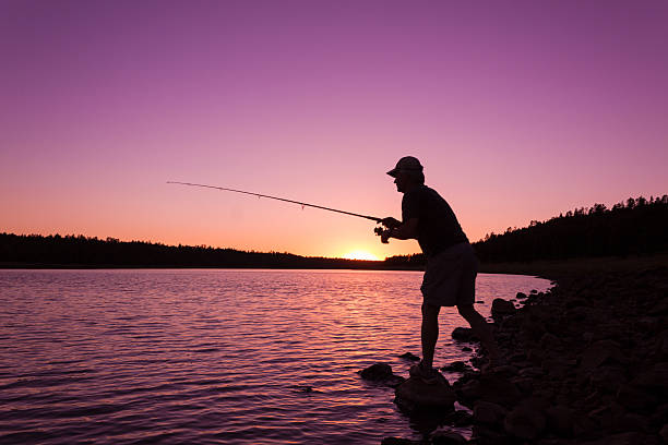 istock Fisherman on lakeshore at sunset 486667612