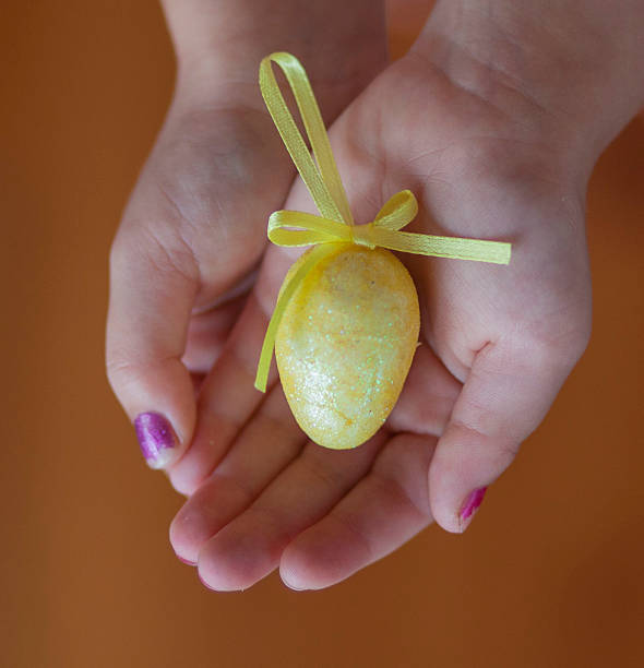 istock Child holding a pretty yellow easter egg in hands 486669097
