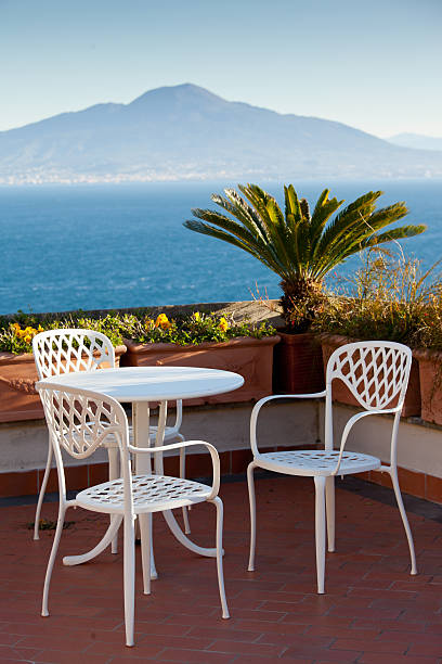 Two wicker chairs on the background of the garden and sea. Seaside chair, relax in the shade at the resort.