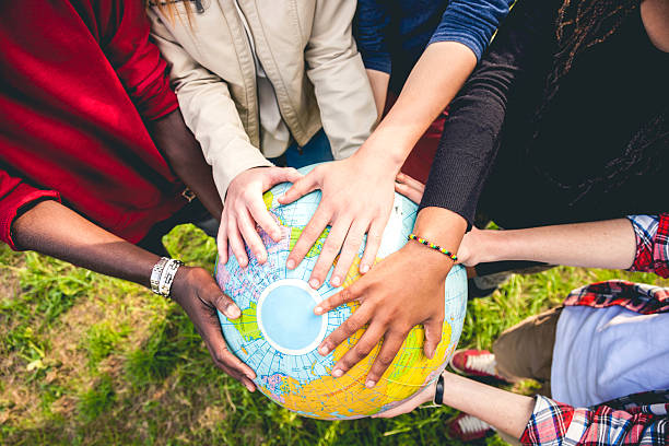 grupo de adolescentes segurando uma terra globo - adolescence teenager globe map - fotografias e filmes do acervo