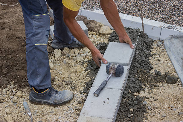 istock worker lays concrete curbs of new sidewalk 486671717