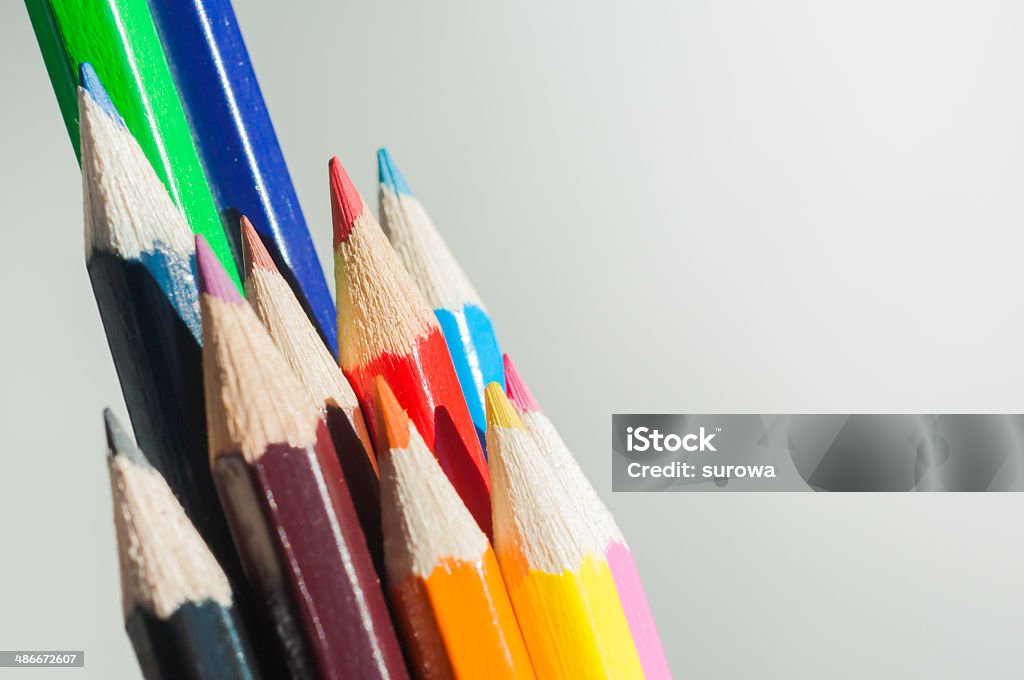 Crayons on white background. Slanting colorful wooden crayons on white background, macro with shallow dof. Selective focus. Arrangement Stock Photo