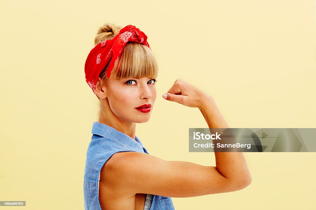 Strong blond woman flexing muscle Strong young blond woman flexing muscle, portrait Girl Power Stock Photo