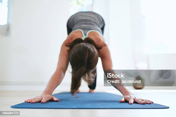 Woman Doing Adho Mukha Svanasana Yoga Pose Stock Photo - Download Image Now - 2015, Active Lifestyle, Adult