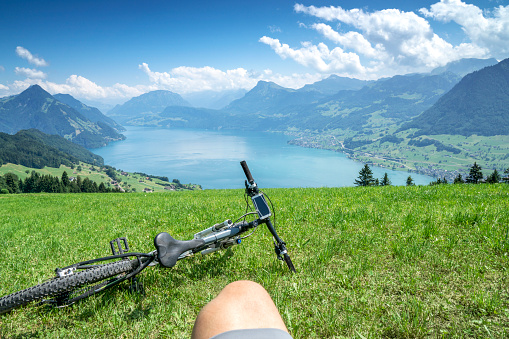 Cycler with mountain bike enjoys the landscape of the Lake Lucerne. View from the mountain resort Buergenstock.