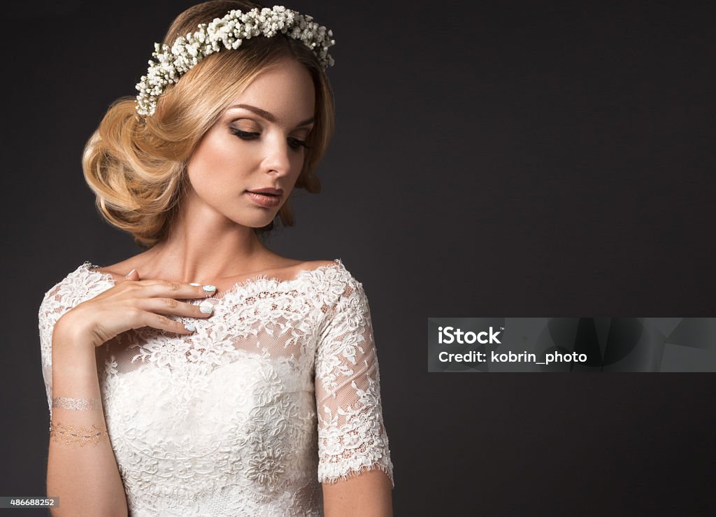 Portrait of a beautiful girl with flowers on her hair Portrait of a beautiful girl with flowers on her hair. Beauty face. Photo shot in the Studio on a black background. Wedding image in the style boho Bride Stock Photo