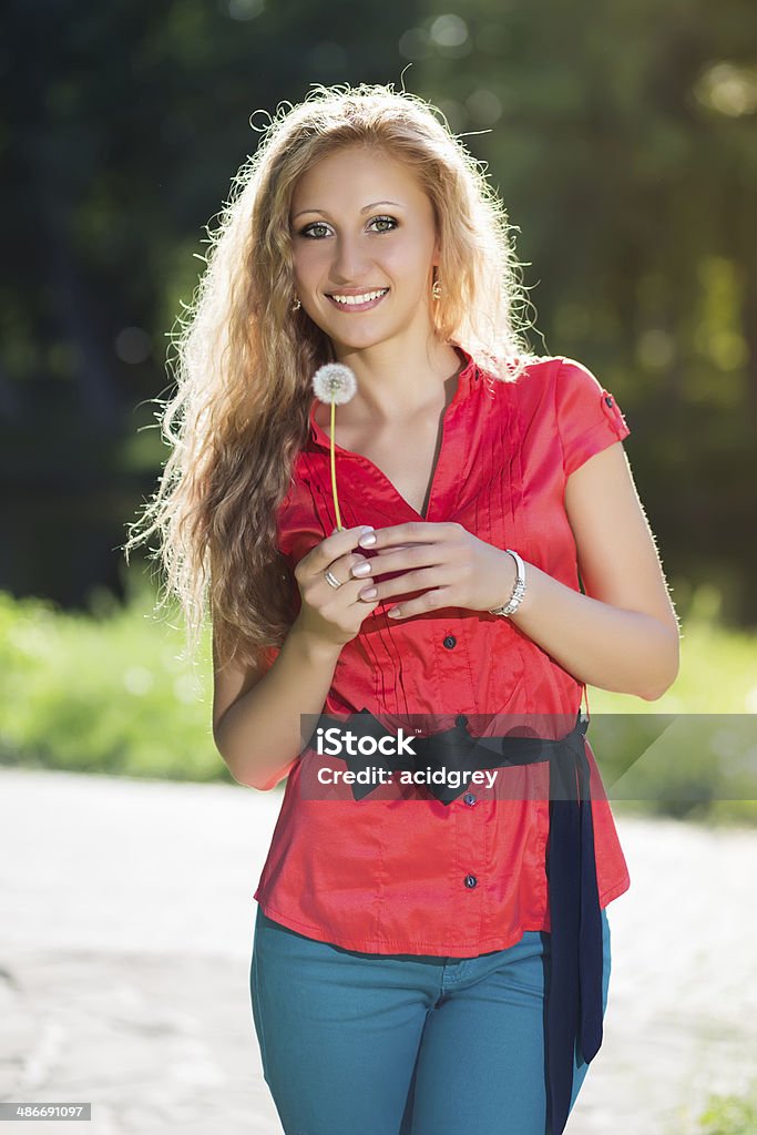 Pretty young blond woman Pretty young blond woman posing with a dandelion Adult Stock Photo