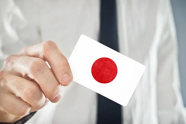 Photo of Japanese Businessman holding business card with Japan Flag