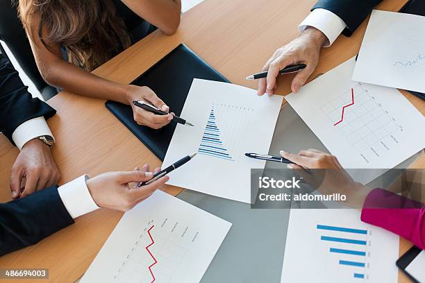 Close Up Of Executives Hands Pointing At Graphs Stock Photo - Download Image Now - 30-39 Years, 60-69 Years, Active Seniors