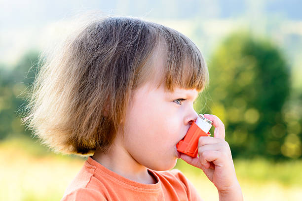 istock Little girl using inhaler on a sunny day 486695518