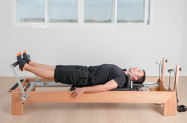 istock Man doing pilates in reformer bed. 486695944