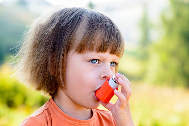 istock Little girl using inhaler on a sunny day 486696110