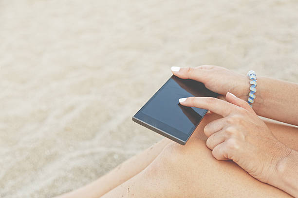 istock Unrecognizable woman uses smartphone on the beach 486697120