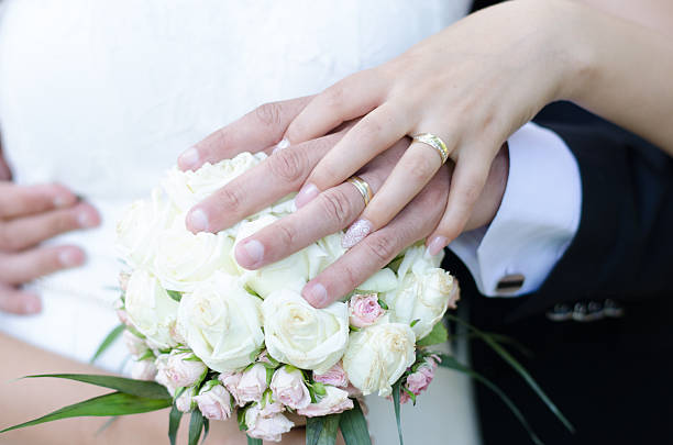 istock Bride and groom with their hands on the bride's bouquet 486698180