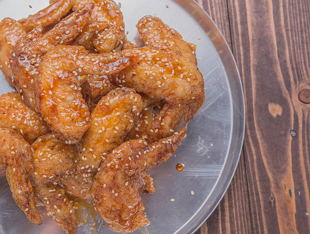 plate tray of fried chicken wings on brown wooden table
