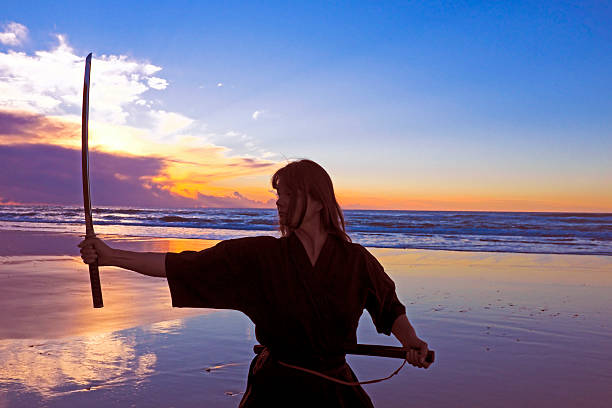 istock Young samurai women with Japanese sword(Katana) at sunset on the 486708339