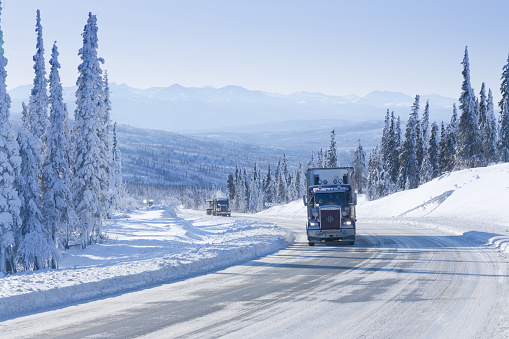 Big Rig Semi-Truck driving on an Icy Arctic Winter Highway in Alaska