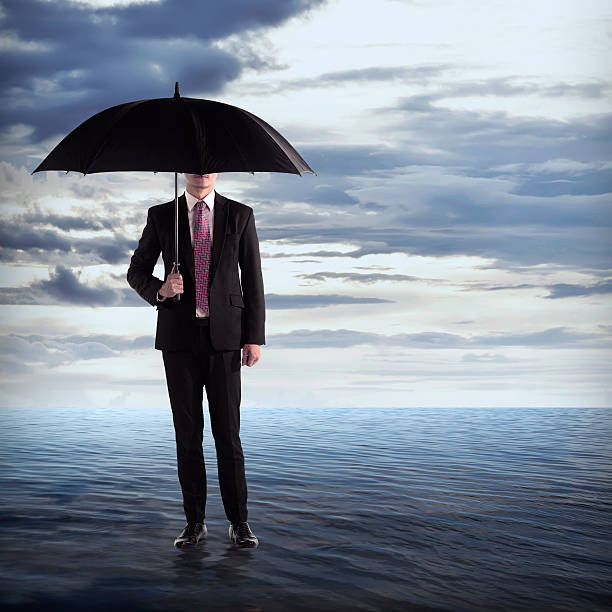 istock Man Holding Umbrella In The Sea 486716422