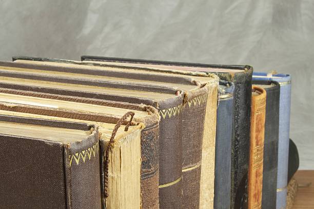 istock Front view of old books stacked on a shelf. 486716452