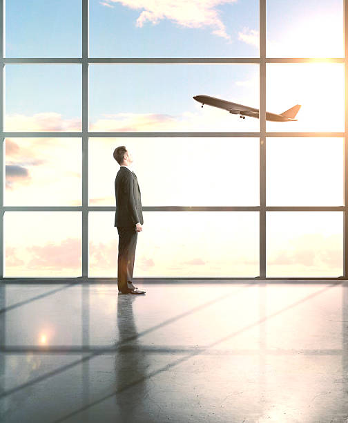 istock businessman looking to airplane 486717964