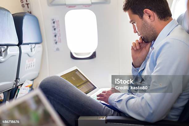 Businessman Working With Laptop On Airplane Stock Photo - Download Image Now - Airplane, Business, Flying