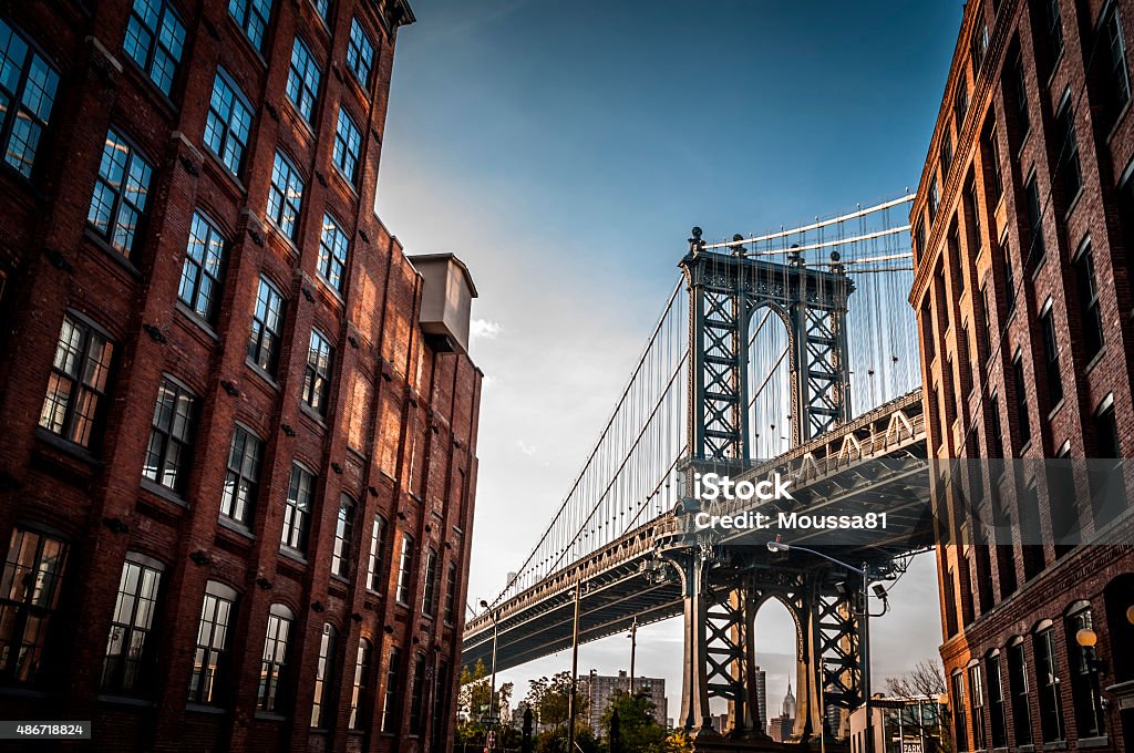 Manhattan bridge Manhattan bridge seen from a narrow alley enclosed by two brick buildings on a sunny day in summer New York City Stock Photo