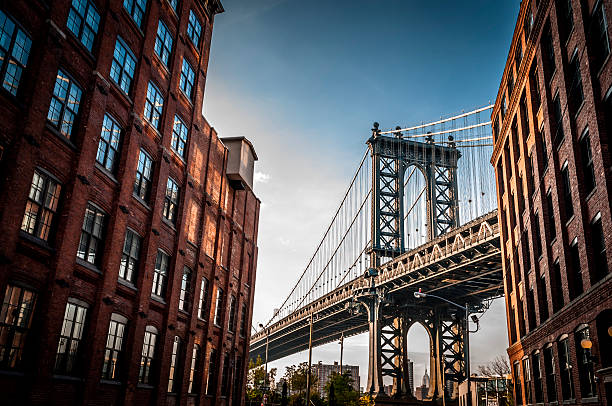 Manhattan bridge Manhattan bridge seen from a narrow alley enclosed by two brick buildings on a sunny day in summer dumbo new york photos stock pictures, royalty-free photos & images