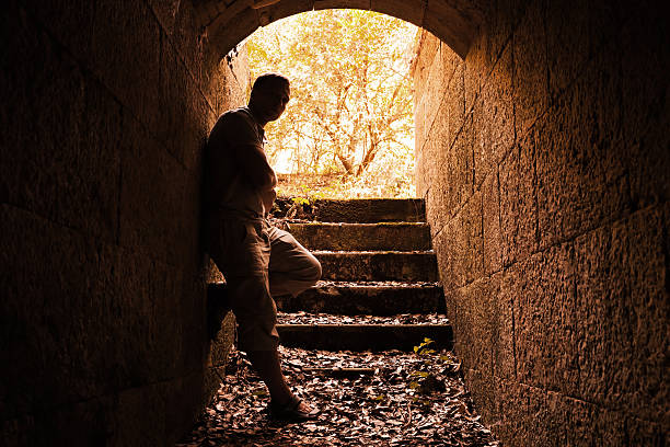 istock Young man stands in dark stone tunnel 486722986