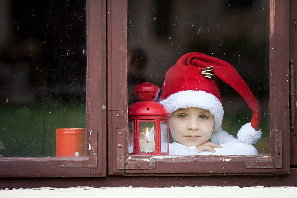 istock Adorable boy, looking through window, waiting for Santa 486724018