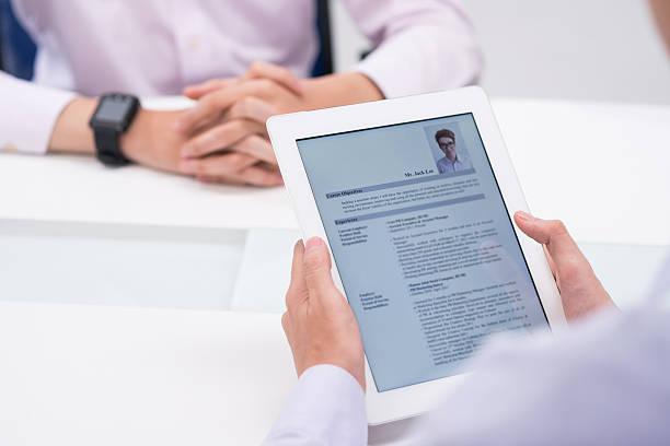 Reading cv Close-up image of employer reading cv of job candidate good cv stock pictures, royalty-free photos & images