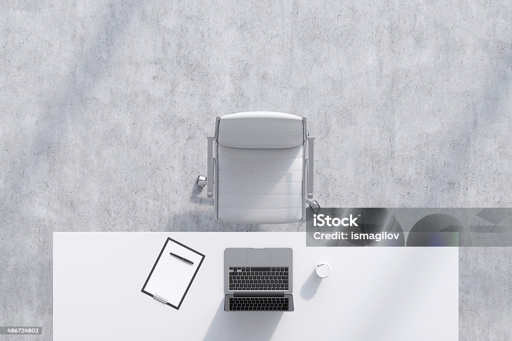 Top view of a workplace in a modern office. Top view of a workplace in a modern office. A white table, white leather chair. Laptop, writing pad for notes and a cup of coffee are on the table. Concrete floor. Office interior. 3D rendering. Office Chair Stock Photo