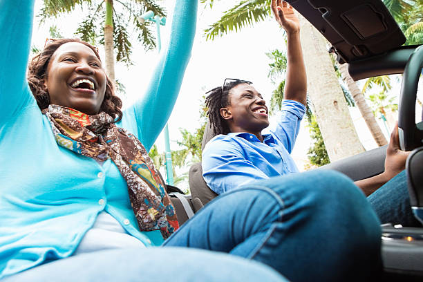 istock Two people with hands up driving in convertible 486724845