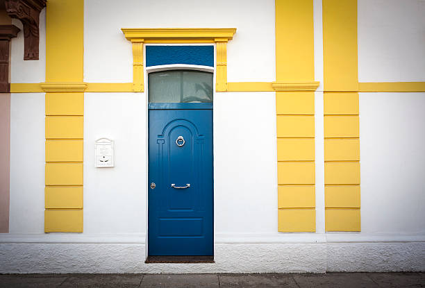 de blanc et de jaune façade avec porte bleue - door nobody macro close up photos et images de collection