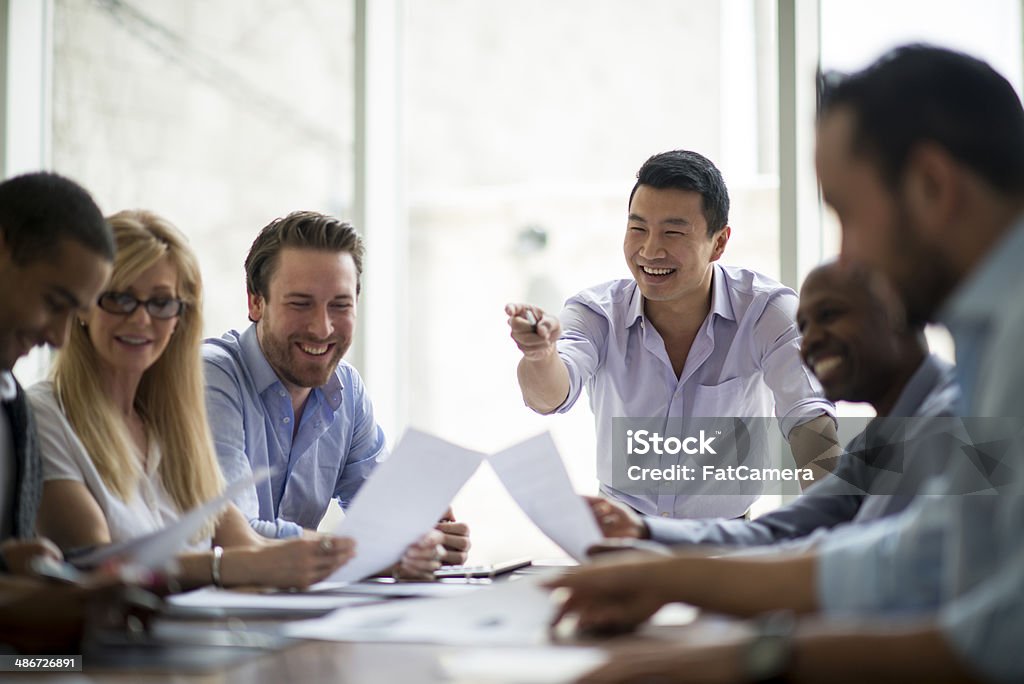 Business meeting - natural light Business people in meeting. No additional lighting. Shot under natural light with large windows behind the group. 20-29 Years Stock Photo