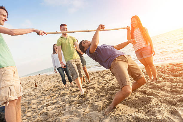 Friends Dancing Limbo at Beach